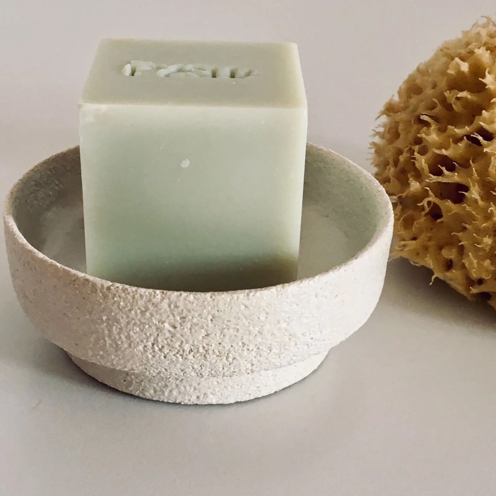 Fysha handmade vegan soap in a handmade ceramic soap dish with a sustainably harvested all-natural sea sponge